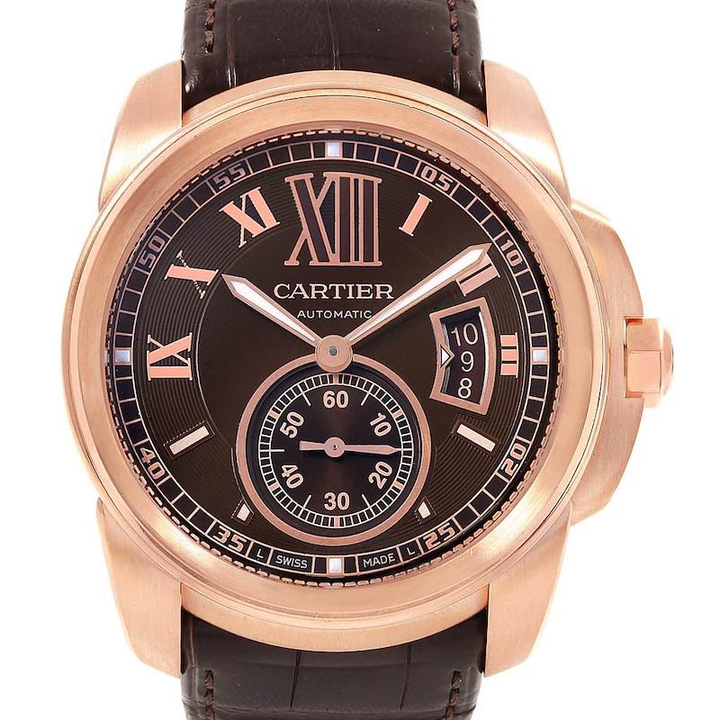 The image shows a front view of the Calibre de Cartier watch by Cartier, highlighting the face, numerals, hands, and date display.