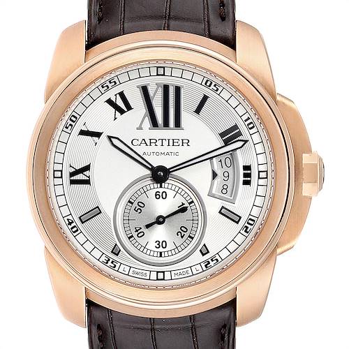 The image shows a front view of the Calibre de Cartier wristwatch by Cartier, highlighting its dial, hour markers, hands, and crown.