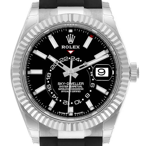 The Rolex Sky-Dweller watch is shown from the front, highlighting its black dial, hour markers, date window, and fluted bezel.