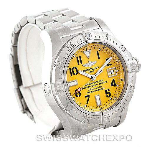 The Breitling Avenger watch is shown at a slight angle displaying its yellow dial, silver case, bezel, and metal bracelet.
