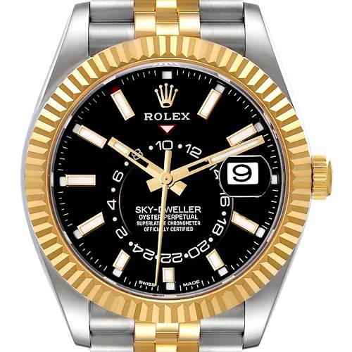 The image shows a front view of the Rolex Sky-Dweller watch, highlighting its black dial, gold fluted bezel, and two-tone bracelet.