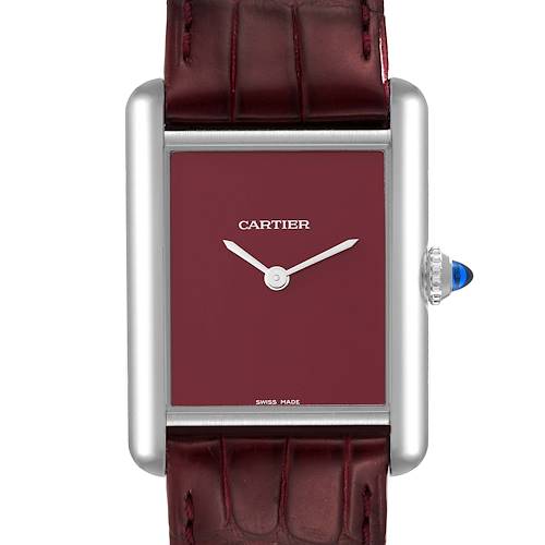 The image shows a front view of the Cartier Tank Must watch, highlighting its rectangular case, burgundy dial, and leather strap.