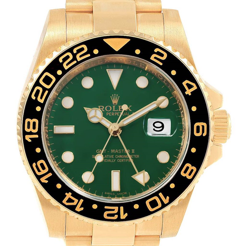 The image shows a frontal view of a Rolex GMT-Master watch, highlighting the green dial, gold case, and black bezel.