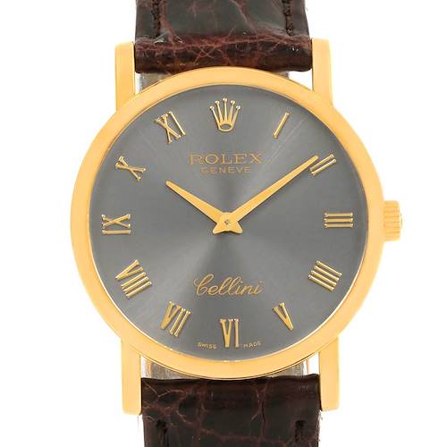 The image shows a front view of a Rolex Cellini watch with a gold case, gray dial, gold Roman numerals, and a brown leather strap.