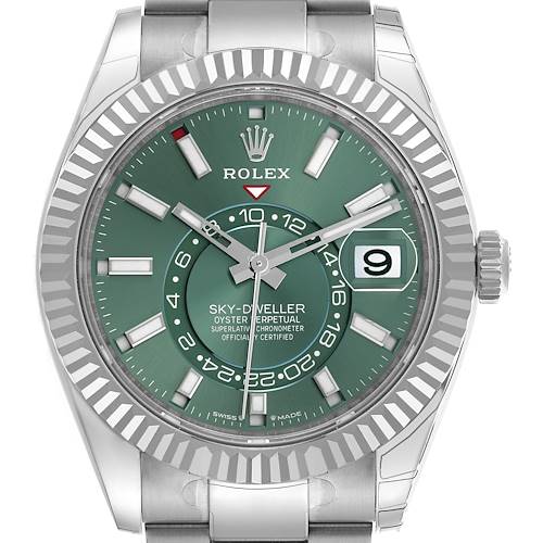 The Rolex Sky-Dweller watch is shown from a front angle, highlighting its green dial, bezel, and bracelet.