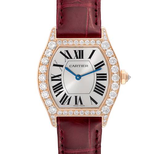 This image shows a straight-on view of a Cartier Tortue watch with a diamond-encrusted bezel and a red leather strap.