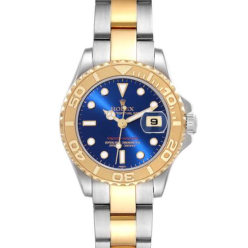 The Rolex Yacht-Master watch is shown from the front, displaying its blue dial, gold bezel, and two-tone bracelet.