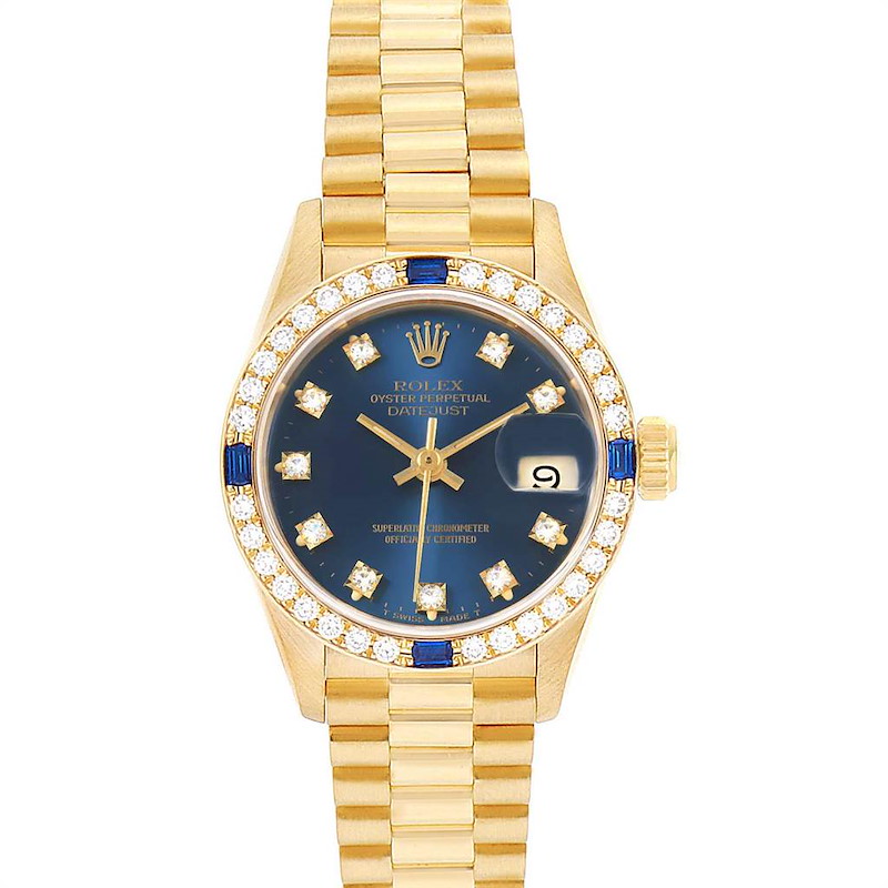 The image shows a Rolex President model watch with a gold band, diamond bezel, blue dial, and date window.