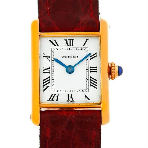 The image shows a Cartier Tank Classic watch, showcasing its rectangular face, Roman numerals, and crown with a blue cabochon, viewed from the front.